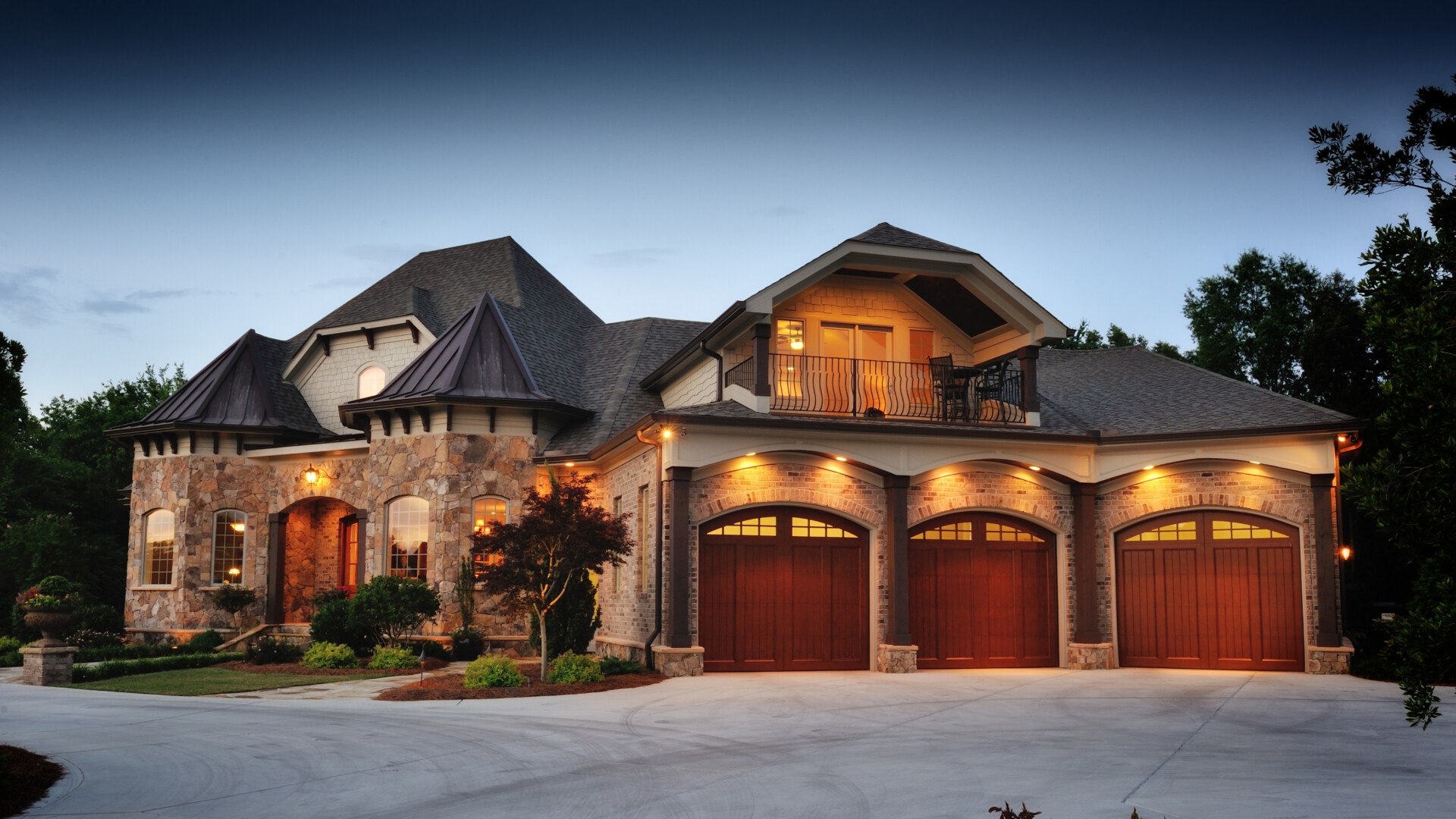 luxury-stone-house-with-garage-and-balcony-at-dusk